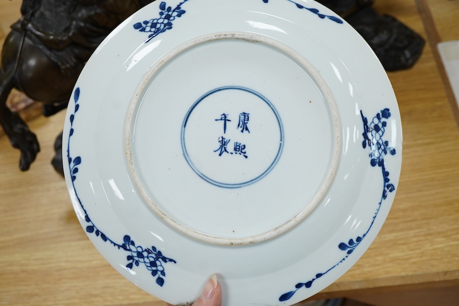 A 19th century Chinese blue and white plate decorated with a flower basket, apocryphal Kangxi four character mark to the base, 25cm in diameter
